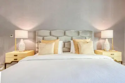 a bedroom with a large white bed with two lamps at Bellavista - Magnificent - 3BR - 29 Boulevard - Partial Burj Khalifa & Fountain Views in Dubai