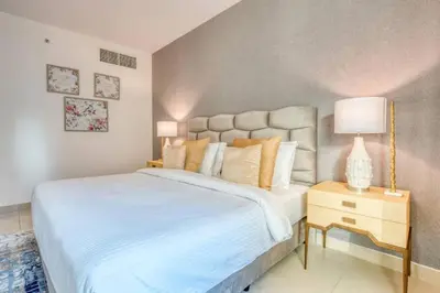 a bedroom with a large white bed and a night stand at Bellavista - Magnificent - 3BR - 29 Boulevard - Partial Burj Khalifa & Fountain Views in Dubai