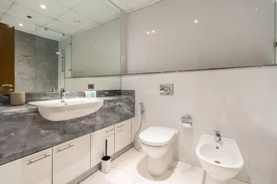 a white bathroom with a sink and a toilet at Breathtaking 1Bed with balcony in Al Habtoor city in Dubai