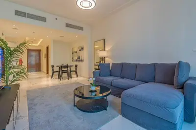 a living room with a blue couch and a table at Breathtaking 1Bed with balcony in Al Habtoor city in Dubai