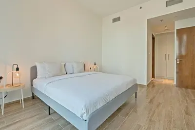 a bedroom with a large white bed and a table at Breathtaking 1Bed with balcony in Al Habtoor city in Dubai