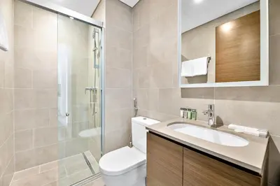 a bathroom with a toilet and a sink and a shower at ALiving Luxury 1BR I Partial Burj khalifa Views I Sobha Creek Vista in Dubai