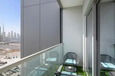 a balcony with chairs and a table and a view of the city at ALiving Luxury 1BR I Partial Burj khalifa Views I Sobha Creek Vista in Dubai