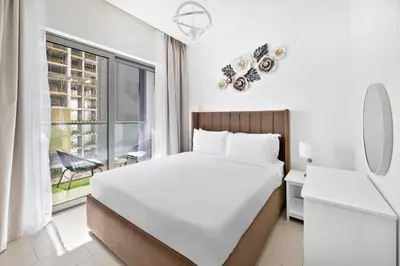 a white bedroom with a large bed and a window at ALiving Luxury 1BR I Partial Burj khalifa Views I Sobha Creek Vista in Dubai