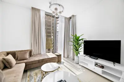 a living room with a couch and a flat screen tv at ALiving Luxury 1BR I Partial Burj khalifa Views I Sobha Creek Vista in Dubai
