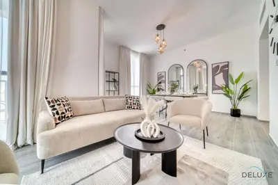 a living room with a couch and a table at Placid 2BR with Assistant Room at Mesk 1 Midtown Dubai Production City by Deluxe Holiday Homes in Dubai