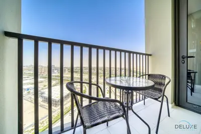 a balcony with a table and chairs and a view at Placid 2BR with Assistant Room at Mesk 1 Midtown Dubai Production City by Deluxe Holiday Homes in Dubai