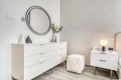a bedroom with a white dresser and a mirror at Placid 2BR with Assistant Room at Mesk 1 Midtown Dubai Production City by Deluxe Holiday Homes in Dubai