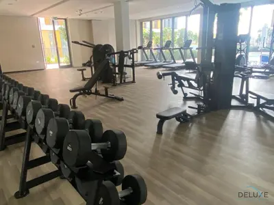 a gym with rows of chairs and weights at Placid 2BR with Assistant Room at Mesk 1 Midtown Dubai Production City by Deluxe Holiday Homes in Dubai