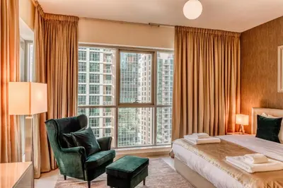 a bedroom with a bed and a chair and a large window at Bellavista - Ultra Modern - 2BR - Boulevard Central - Burj Khalifa View in Dubai