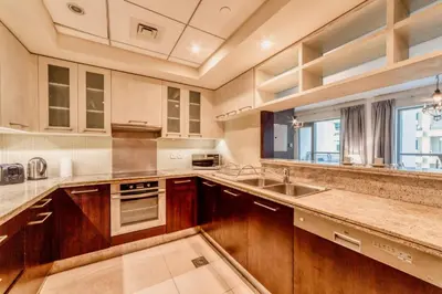a kitchen with wooden cabinets and a sink at Bellavista - Ultra Modern - 2BR - Boulevard Central - Burj Khalifa View in Dubai