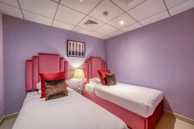 two beds in a room with purple walls at Bellavista - Spacious - 1BR with Extra Room - 29 Boulevard - Partial Fountain View in Dubai