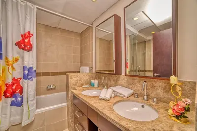 a bathroom with a sink and a large mirror at Bellavista - Spacious - 1BR with Extra Room - 29 Boulevard - Partial Fountain View in Dubai
