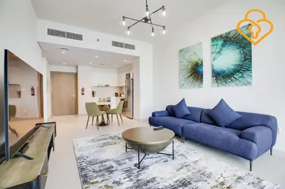 a living room with a blue couch and a table at Keysplease Spectacular Views Modern 1BR Creek Gate 602 in Dubai
