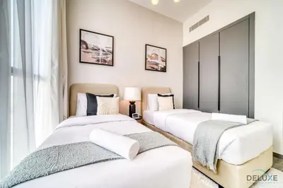 two beds in a room with white walls at Impressive 2BR with Assistant Room at Mesk 1 Midtown Dubai Production City by Deluxe Holiday Homes in Dubai