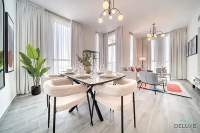 a dining room with a table and chairs at Impressive 2BR with Assistant Room at Mesk 1 Midtown Dubai Production City by Deluxe Holiday Homes in Dubai