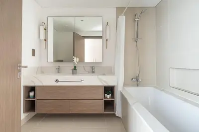 a bathroom with a sink and a tub and a mirror at Frank Porter - 17 Icon Bay in Dubai