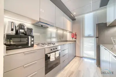 a kitchen with a stove and a microwave at Harmonious 2BR with Assistant Room at Mesk 1 Midtown Dubai Production City by Deluxe Holiday Homes in Dubai