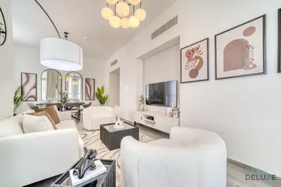 a living room with white furniture and a tv at Harmonious 2BR with Assistant Room at Mesk 1 Midtown Dubai Production City by Deluxe Holiday Homes in Dubai