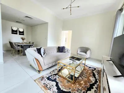 a living room with a couch and a table at Royal Maison Luxurious 2 Br in Business Bay in Dubai
