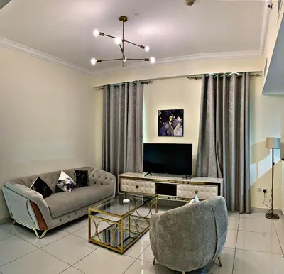 a living room with a couch and a tv at Royal Maison Luxurious 2 Br in Business Bay in Dubai