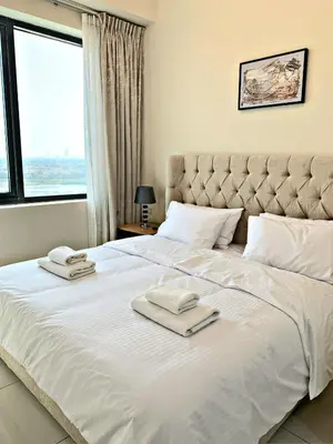 a bedroom with a large white bed with towels on it at Royal Maison Luxurious 2 Br in Business Bay in Dubai