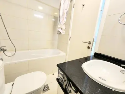 a bathroom with a sink and a toilet and a tub at Royal Maison Luxurious 2 Br in Business Bay in Dubai