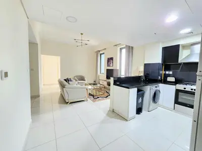 a large white kitchen with a washer and dryer at Royal Maison Luxurious 2 Br in Business Bay in Dubai