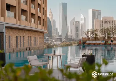 a pool with two chairs and a table in a city at Fashion Avenue - Dubai Mall in Dubai