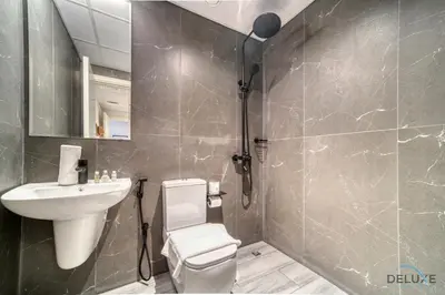 a bathroom with a white toilet and a sink at Idyllic 2BR with Assistant Room at Mesk 1 Midtown Dubai Production City by Deluxe Holiday Homes in Dubai