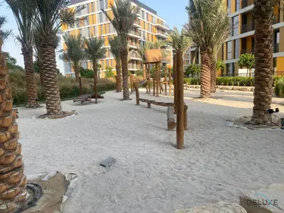 a playground with palm trees in front of a building at Idyllic 2BR with Assistant Room at Mesk 1 Midtown Dubai Production City by Deluxe Holiday Homes in Dubai