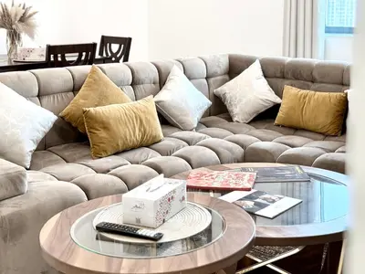 a living room with a couch and a glass table at Royal Maison Deluxe 2 Br in Executive Bay in Dubai