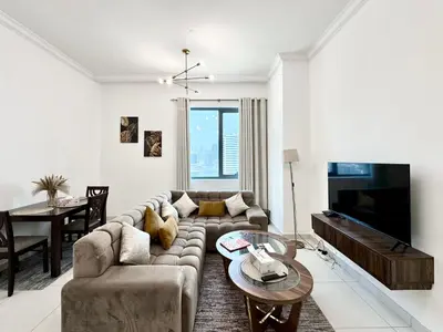a living room with a couch and a table at Royal Maison Deluxe 2 Br in Executive Bay in Dubai