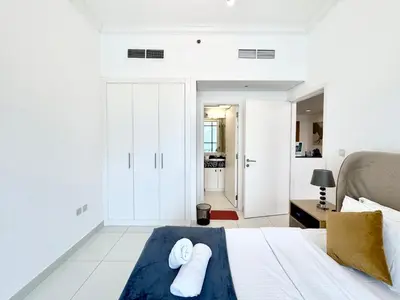 a bedroom with a bed with two towels on it at Royal Maison Deluxe 2 Br in Executive Bay in Dubai