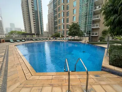 a large blue swimming pool in the middle of buildings at 2BR Burj View with Balcony, Pool, Gym & Walk to Dubai Mall in Dubai