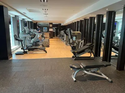 a gym with a row of treadmills and machines at 2BR Burj View with Balcony, Pool, Gym & Walk to Dubai Mall in Dubai