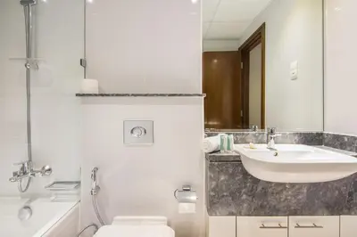 a bathroom with a sink and a toilet and a mirror at Stunning 1BR AL Habtoor City -Meera Tower 1108 in Dubai