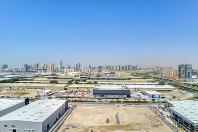 an aerial view of a construction site with a city in the background at Suave 2BR with Assistant Room at Mesk 1 Midtown Dubai Production City by Deluxe Holiday Homes in Dubai
