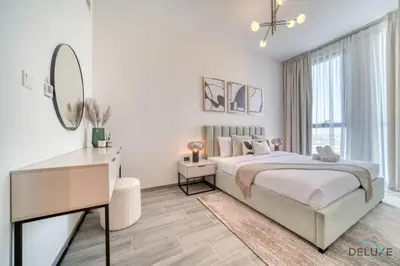 a bedroom with a bed and a desk and a mirror at Refined 2BR with Assistant Room at Mesk 1 Midtown Dubai Production City by Deluxe Holiday Homes in Dubai