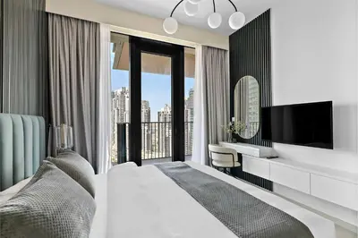 a bedroom with a bed and a desk and a tv at Silkhaus elegant and luxury 1BDR Downtown in Dubai