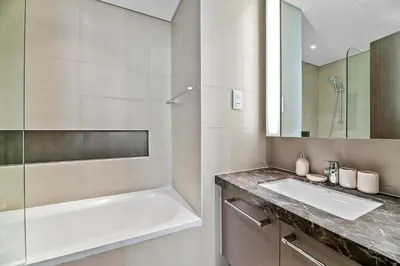 a bathroom with a tub and a sink and a mirror at Silkhaus elegant and luxury 1BDR Downtown in Dubai