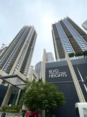 two tall buildings in a city with a sign forbid heights at Silkhaus elegant and luxury 1BDR Downtown in Dubai