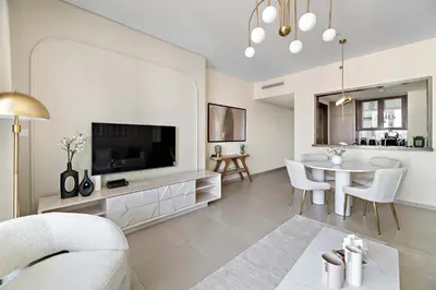 a living room with a large television and a table at Silkhaus elegant and luxury 1BDR Downtown in Dubai