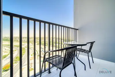 a table and chairs on a balcony with a view at Charming 2BR with Assistant Room at Mesk 1 Midtown Dubai Production City by Deluxe Holiday Homes in Dubai