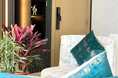 a pillow sitting on a chair next to some plants at The Shrashi Suites, Dubai Creek Harbour - Paradise on the Island with Dubai Skyline & Waterfront View in Dubai