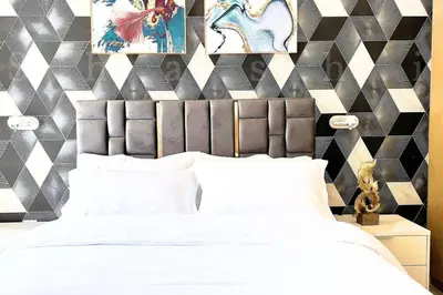 a bedroom with a white bed and a geometric wall at The Shrashi Suites, Dubai Creek Harbour - Paradise on the Island with Dubai Skyline & Waterfront View in Dubai