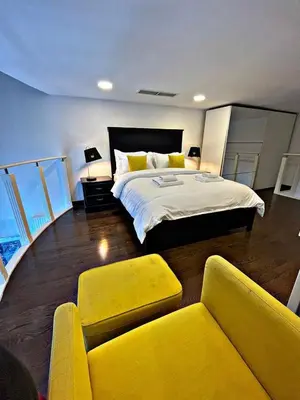 a bedroom with a large bed and yellow furniture at Stunning Duplex Studio in JLT in Dubai