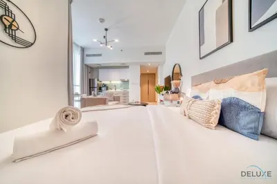 a large white bedroom with pillows on a bed at Splendid Studio at Mesk 1 Midtown Dubai Production City by Deluxe Holiday Homes in Dubai