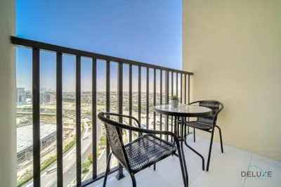 a balcony with a table and chairs and a view at Prime Studio at Mesk 1 Midtown Dubai Production City by Deluxe Holiday Homes in Dubai