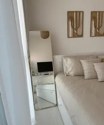 a bedroom with a mirror next to a bed at Tranquil Studio in Damac Hills in Dubai